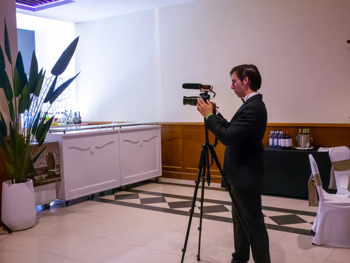 Operador de cámara grabando con trípode en el salón del hotel Elba durante la gala benéfica contra el cáncer